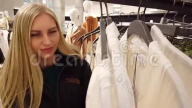 女孩在商场里挑选衣服。